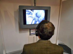 ライブラリー・マルチメディア工房の視聴ブースでヘッドホンをつけて作品鑑賞している写真