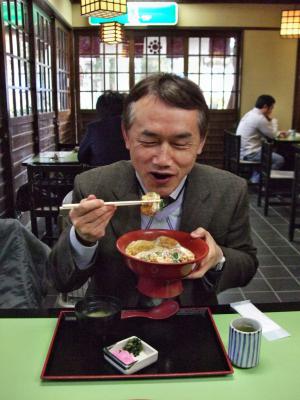 かき丼を食べている男性の写真
